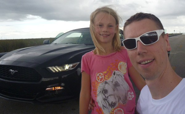 Gregor mit Tochter vor einem Mustang