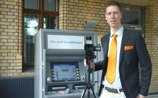 Gregor mit Kamera am Bankautomaten